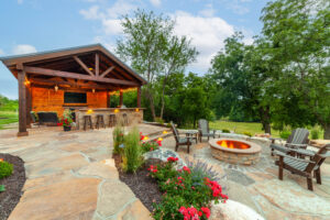covered outdoor kitchen with bar seating and fire pit
